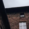 Brick building facade with arched windows under overcast sky