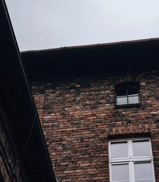 Brick building facade with arched windows under overcast sky