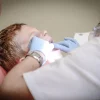 Child receiving dental check-up from dentist wearing gloves in clinic setting