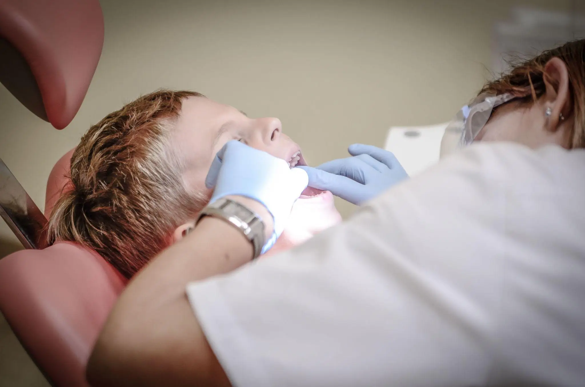 Child receiving dental check-up from dentist wearing gloves in clinic setting