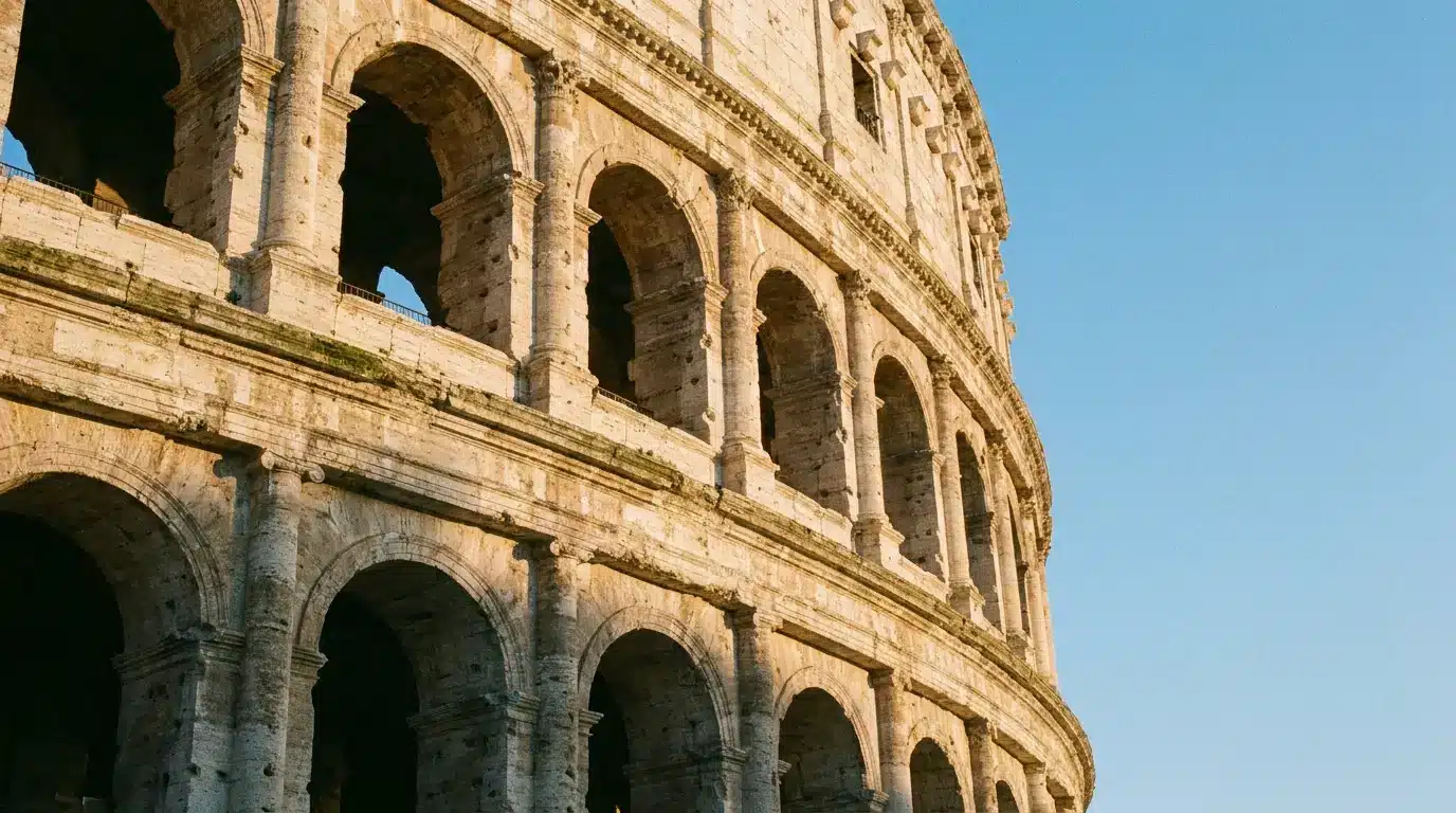 Ancient stone amphitheater arches against clear blue sky in warm daylight