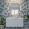 Round mirror with backlighting above modern white basin in bathroom with blue hexagonal tiles