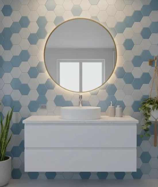 Round mirror with backlighting above modern white basin in bathroom with blue hexagonal tiles